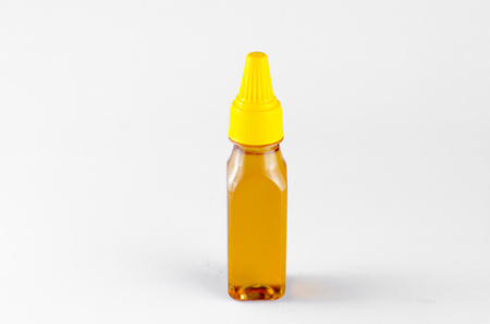 Pure Bee's Honey in plastic container over white backgroundの写真素材