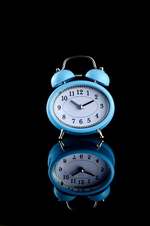 Blue bell clock over black backgroundの写真素材