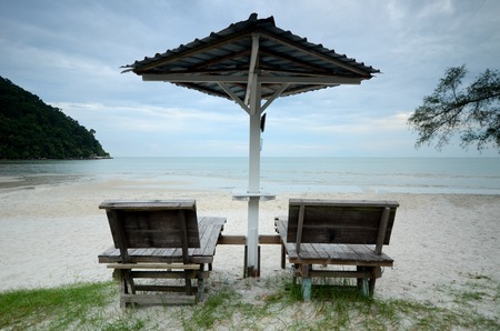 Sun loungers on the beach with wooden chair and umbrellaの写真素材