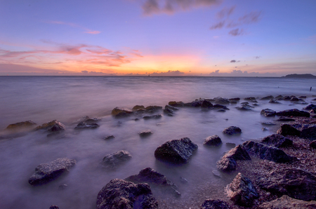 Sunset view with rock in oceanの写真素材
