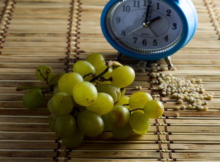 Over ripe Grape with barley and clockの写真素材