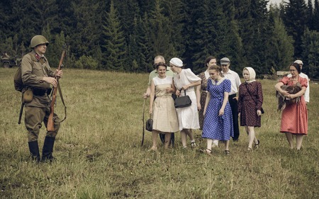 PERM, RUSSIA - JULY 30, 2016: Historical reenactment of World War II, summer, 1942. Soviet soldier and civilians.のeditorial素材