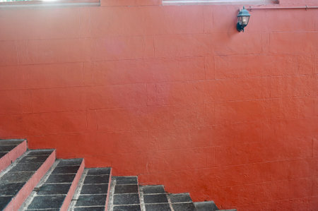 Red wall and stairs with street lamp in the city, Thailand.の写真素材