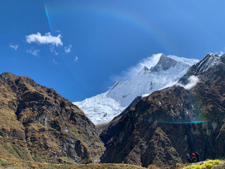 Mountain landscape with snowcapped peaks and rainbow in the skyの写真素材