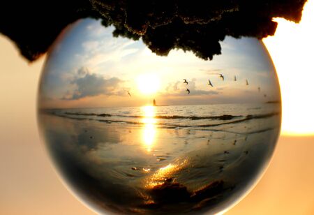 Beautiful sunset captured through a glass lens ball at Cape Henlopen State Park, Lewes, Delaware, U.S.Aの写真素材