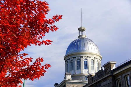 Old Montreal, Canada - October 25, 2019 - The view of the exterior dome of Bonsecours Market surrounded by striking red color of fall foliageのeditorial素材