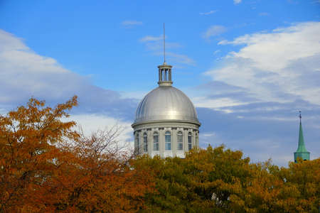 Old Montreal, Canada - October 25, 2019 - The view of the exterior dome of Bonsecours Market surrounded by striking colors of fall foliageのeditorial素材