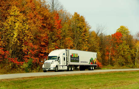 Ontario, Canada - October 27, 2019 - The view of large truck on the Route 401 highway with stunning colors of fall foliageのeditorial素材