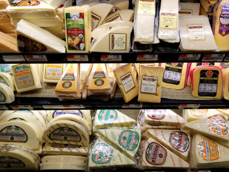 Wilmington, Delaware, U.S.A - December 10, 2020 - Variety of cheese brands, flavors and sizes on the cold shelvesのeditorial素材