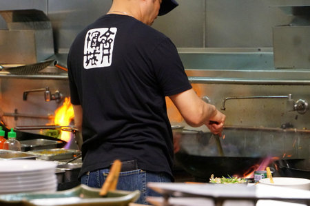 Philadelphia, Pennsylvania, U.S - December 23, 2018 - A cook using a wok in the kitchen at a restaurantのeditorial素材