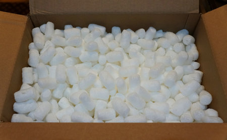 White packing peanuts inside a brown box to secure shipment