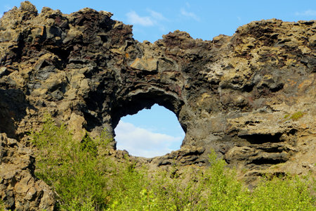 The view of the unique rock structure and the cave at Dimmuborgir Lava Formations near Lake Myvatn, Icelandの写真素材