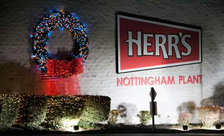 Nottingham, Pennsylvania, U.S.A - December 28, 2021 - The building of Herr's Food Inc headquarters decorated with wreath in colorful Christmas lightsのeditorial素材