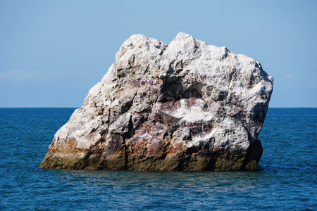 The view of a white rock island in the middle of the ocean on a sunny day near Mazatlan, Mexicoの写真素材