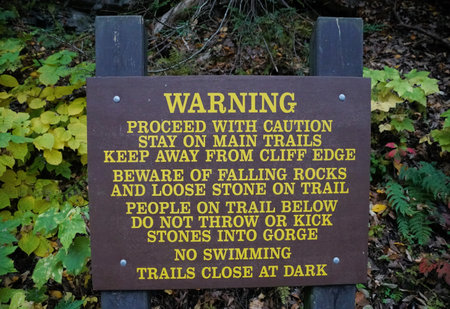 Ithaca, New York, U.S.A - October 17, 2022 - The warning and no swimming wooden sign displayed at Buttermilk Fallsのeditorial素材