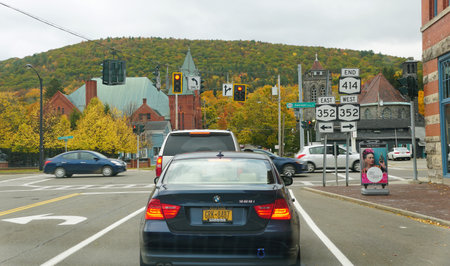 Corning, New York, U.S.A - October 18, 2022 - The traffic lights on Tioga Avenue with the background of fall foliageのeditorial素材