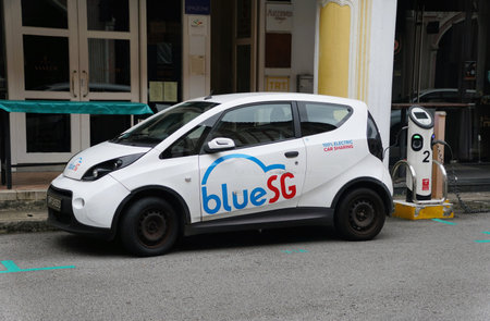 Bras Basah, Singapore - February 18, 2023 - The Blue SG electric car sharing service charging on the...
