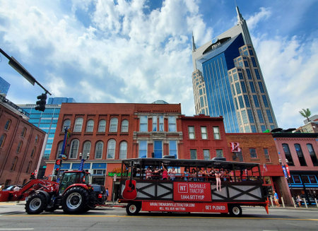 Nashville, Tennessee, U.S.A - June 26, 2022 - Passengers on the red color of Nashville Tractor moving along the bars and restaurants on Broadway Streetのeditorial素材