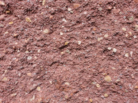 Closeup of a rough surface and textured red background of an uneven brickの写真素材