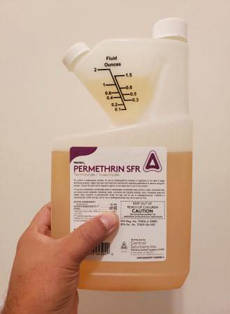 Wilmington, Delaware, U.S.A - September 27, 2023 - Holding a 32 ounce of Permethrin SFR bottle, a pesticide to kill pests on plantsのeditorial素材