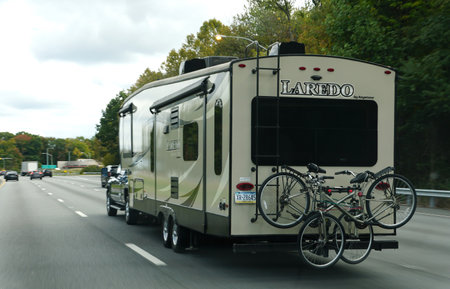 Blue Bell, Pennsylvania, U.S.A - October 15, 2023 - A white Laredo RV with bicycles moving on the...