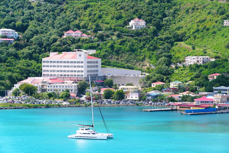 Tortola, British Virgin Islands - February 22, 2024 - The distance view of the buildings in the city and private yacht by the bayのeditorial素材