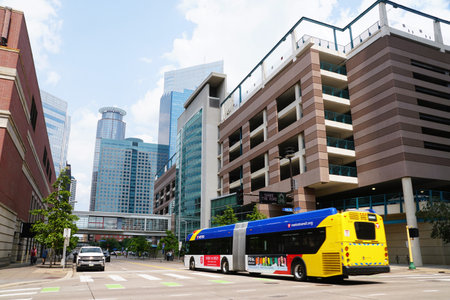 Minneapolis, Minnesota, U.S - July 13 2024 - The view of the tall buildings, Skyway bridge, hotels, Metro transit bus and traffic on S 11th Street on a sunny dayのeditorial素材