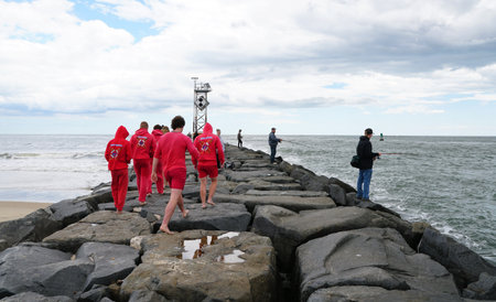 Ocean City, Maryland, U.S.A - May 23, 2025 - A group of lifeguards and fisherman on the rocky...