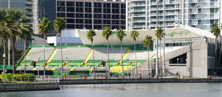 St Petersburg, Florida, U.S.A - Jan 2, 2026 - Al Lang Stadium, a historic waterfront sports stadium features green and yellow seating sections, lined with tall palm trees near urban high-rise buildingsのeditorial素材