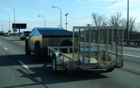Philadelphia, Pennsylvania, U.S.A - Feb 21, 2026 - Tesla Cybertruck towing a utility trailer loaded...