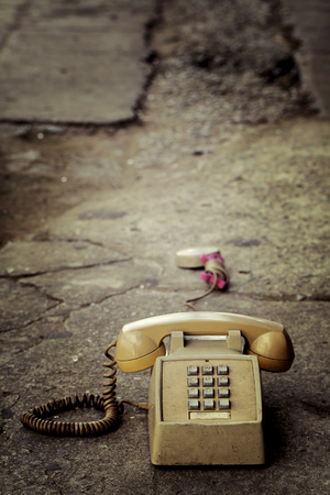 Dirty old phone on the floor and old concrete.の写真素材