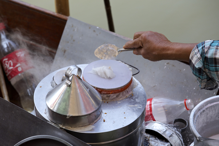 Food vendor at the Damnoen Saduak Floating Market cooking a Thai dessert, Thailand. Slight motion blur.の写真素材