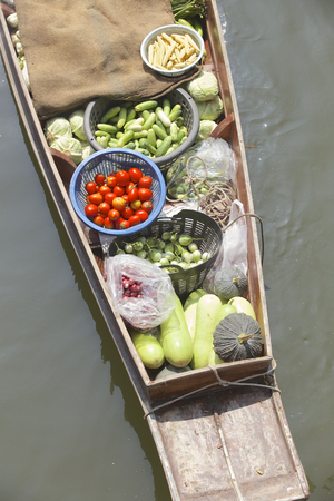 A lady selling fruit from her boat at a floating market in Thailand. Image taken at Damnoen Saduak floating market near Bangkok. Taken from above on a bridge.の写真素材