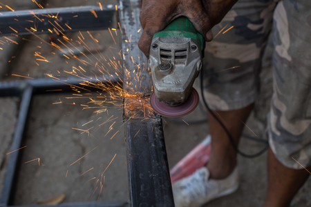 Closeup cutting process of metal material with sparks, industrialの写真素材