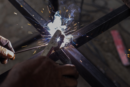 Iron welding with bright light and smoke at manufacturingの写真素材
