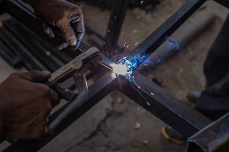 Iron welding with bright light and smoke at manufacturing