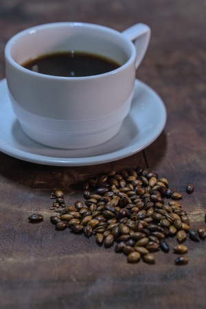 Black coffee in a white cup put on an old wooden tableの写真素材
