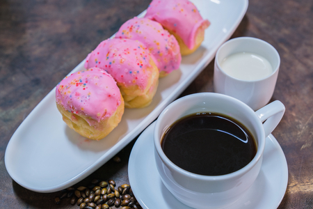 Donut dumplings are placed in a plate with black coffee.の写真素材