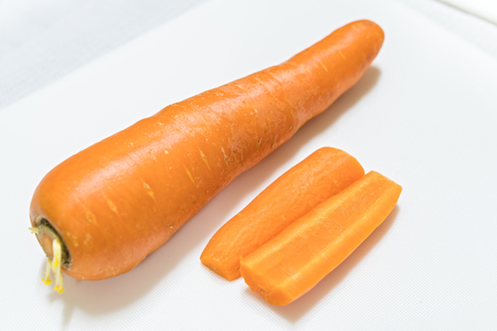 Sliced carrots with knife isolated on white backgroundの写真素材