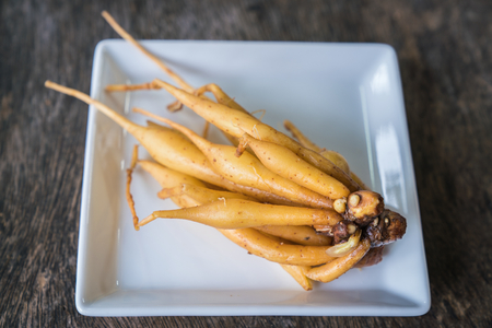 ingredient of thailand spices called galingale on wooden background.の写真素材