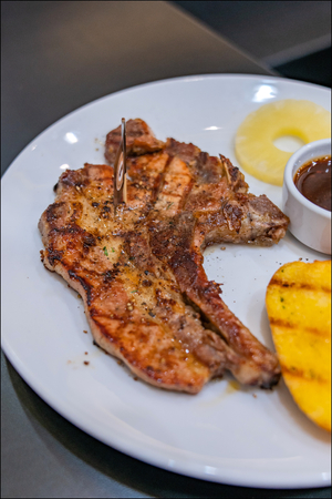 Steak on a white plate with potatoes and salads.の写真素材