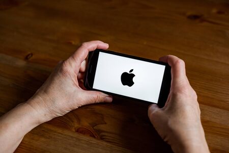 Apple logo sign application screen on mobile phone online retail service, hands onのeditorial素材