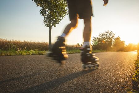 Man roller skating on the cycle path during lovely summer sunset, sport concept, motion blurred...