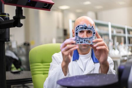 Quality engineer, scanning components by professional optical 3D scanner with a turntable,...