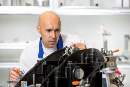 Quality engineer measuring plastic components by digital meter on the fixture, automotive and...
