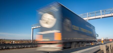 Truck passing through a toll gate on a highway, highway charges, motion blurred imageの写真素材