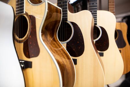 Close up of classic guitar drapped in a row in a huge musical shop, instrument shop