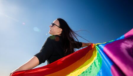 Woman with rainbow flag, background with extra copy space
