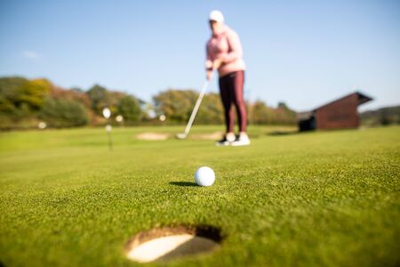 Female begginer golf player playing golf on the training ground, sport concept