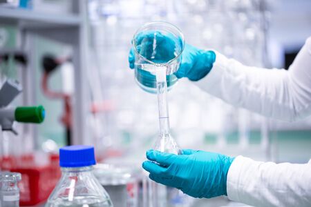 Professional female chemist researcher carrying out scientific research in a lab, industrial...